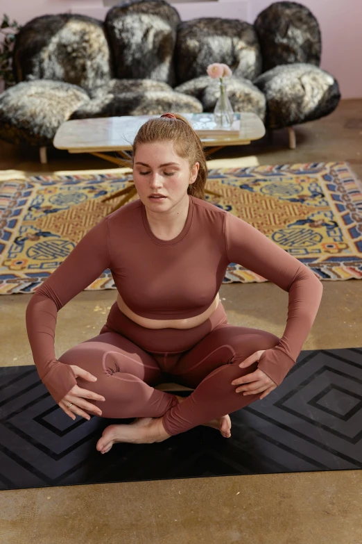 a woman sitting on a yoga mat in a living room, renaissance, in spandex suit, terracotta, medium-shot, performance