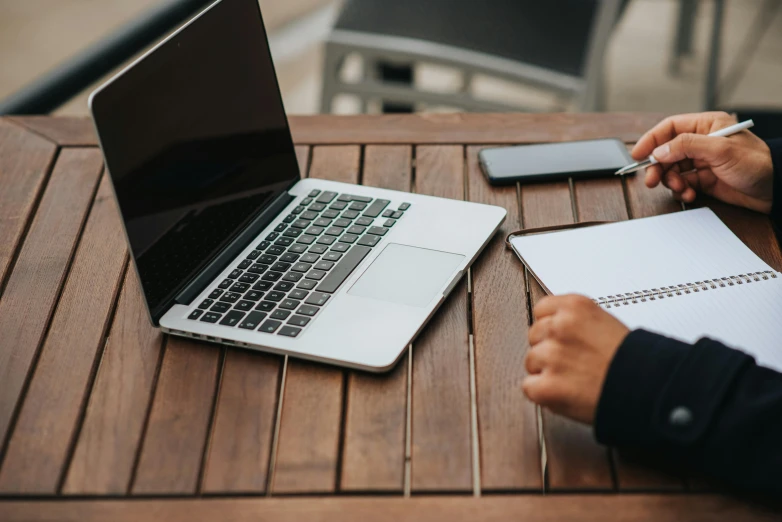 a person sitting at a table with a laptop and notebook, professional grade, thumbnail, blank