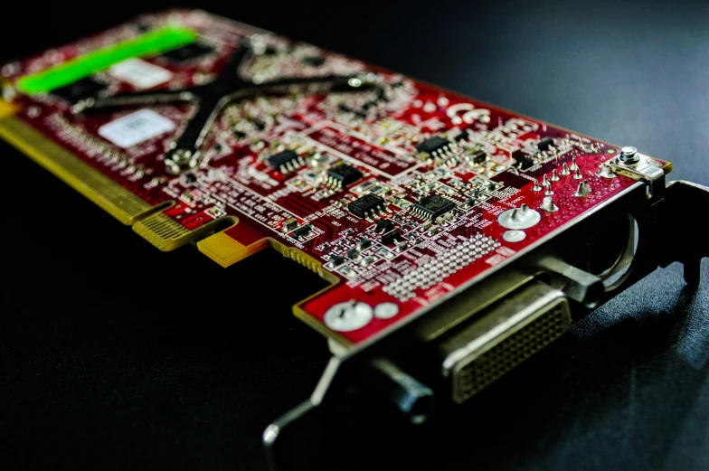 a close up of a video card on a table, pexels, red mechanical body, crusty electronics, paul barson, golden computers