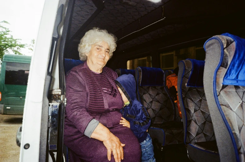 a woman sitting in the passenger seat of a bus, by Nathalie Rattner, grandma, woman holding another woman, 1999 photograph, daniil kudriavtsev