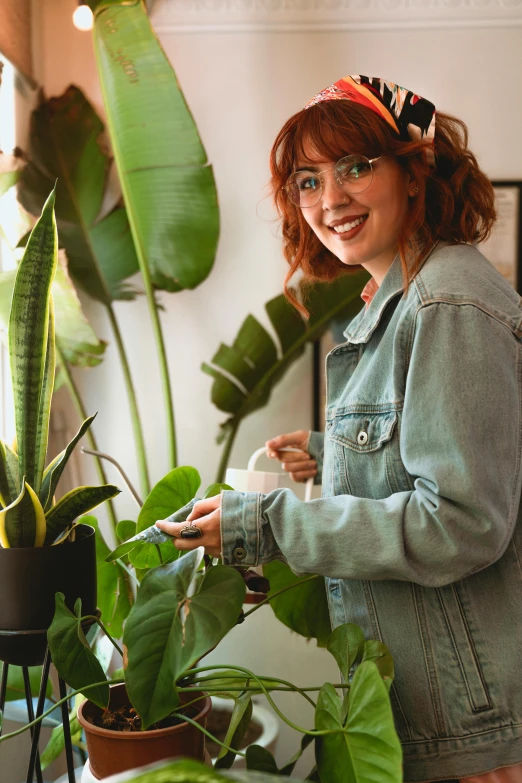 a woman standing next to a potted plant, ginger hair with freckles, smiling playfully, monstera deliciosa, kailee mandel