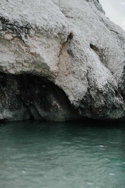 a man standing on top of a rock next to a body of water, dark cave, capri coast, river running through it, trending photo