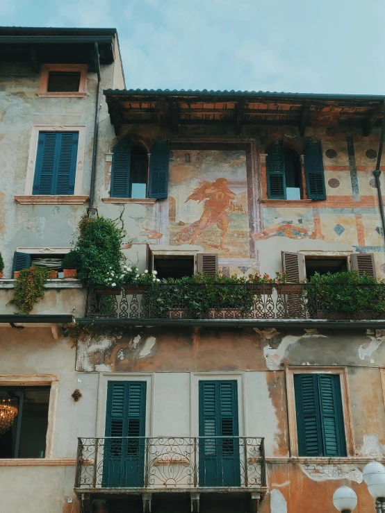 an old building with lots of windows and balconies, an album cover, inspired by Michelangelo Buonarotti, pexels contest winner, renaissance, wall painting, 🤬 🤮 💕 🎀, olive garden, a quaint