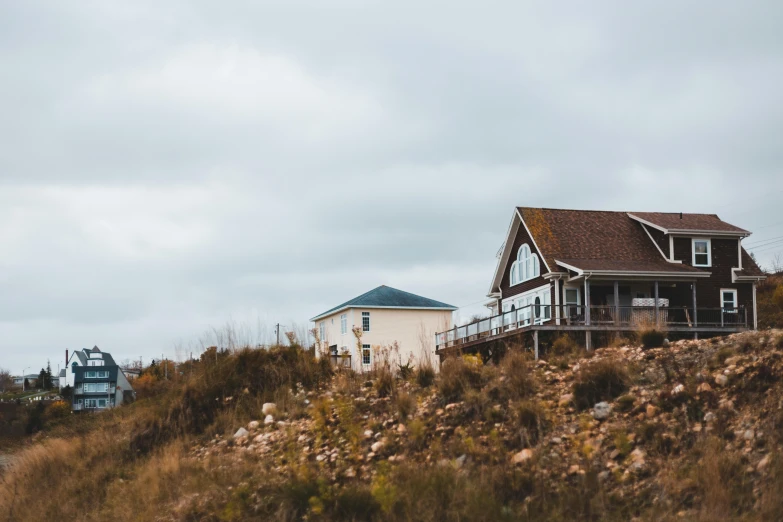 a couple of houses sitting on top of a hill, unsplash, slight overcast weather, vacation photo, cottage close up, exterior photo