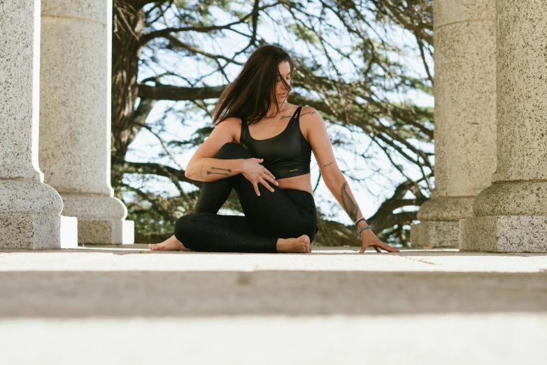 a woman sitting on the ground in a yoga pose, pexels contest winner, renaissance, arched back, wearing black tight clothing, sydney park, background image