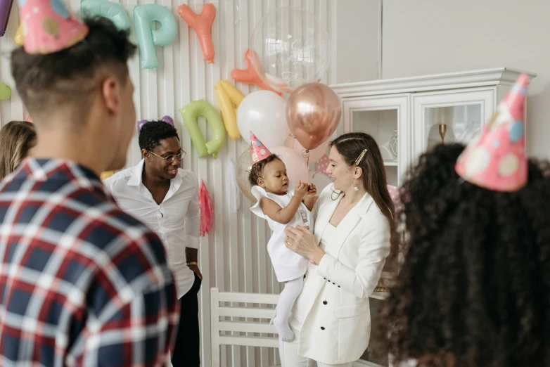 a group of people at a birthday party, by Emma Andijewska, pexels contest winner, fan favorite, any racial background, with a kid, cute woman