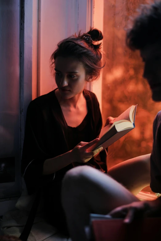 a woman sitting next to a man reading a book, a portrait, pexels contest winner, romanticism, bisexual lighting, scary stories, medium shot of two characters, teenage girl