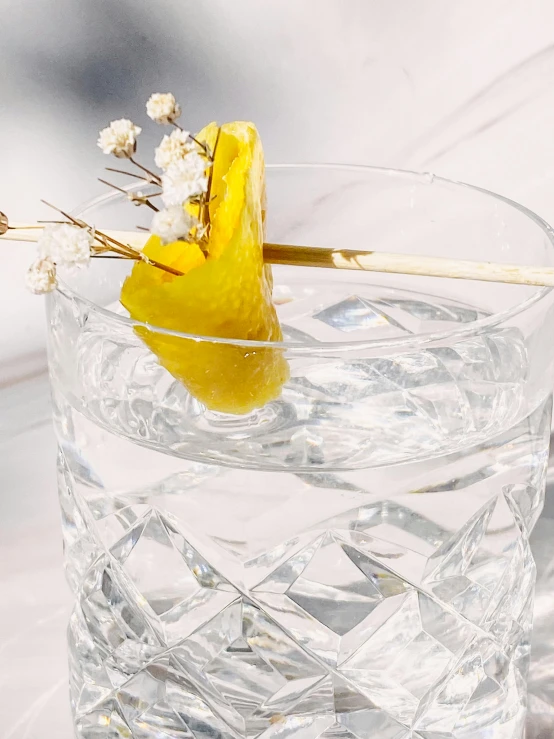 a glass of water sitting on top of a wooden table, inspired by Carlo Martini, unsplash, renaissance, white and gold kintsugi, chopsticks, 🍸🍋, product display photograph