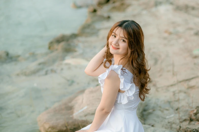 a woman in a white dress sitting on a rock, inspired by Kim Du-ryang, pexels contest winner, wan adorable korean face, beautiful girlfriend, slightly pixelated, brown