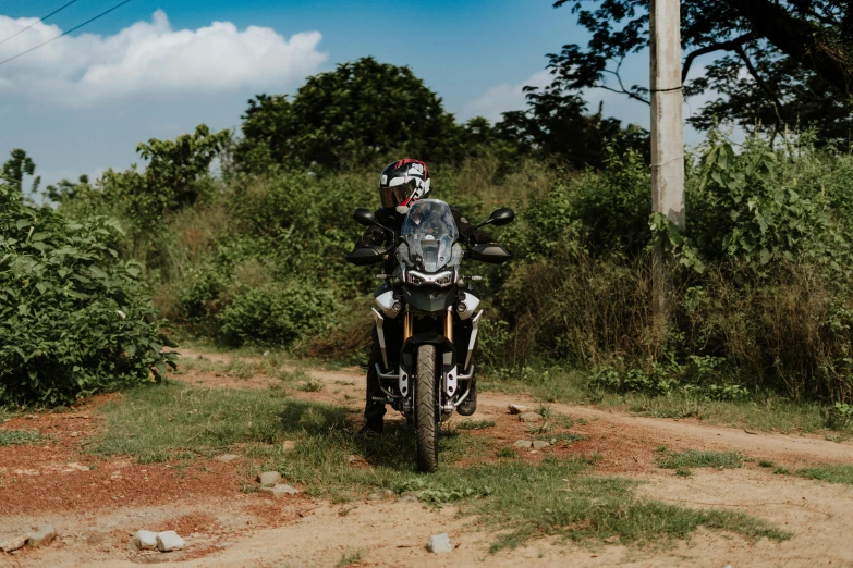 a man riding a motorcycle down a dirt road, a portrait, pexels contest winner, avatar image, jungles in the background, curvy build, high quality upload