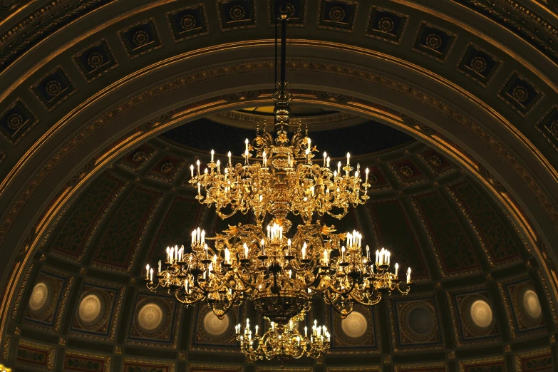 a chandelier hanging from the ceiling of a building, inspired by Sydney Prior Hall, pexels, baroque, parliament, shades of gold display naturally, gallery lighting, kris kuksi