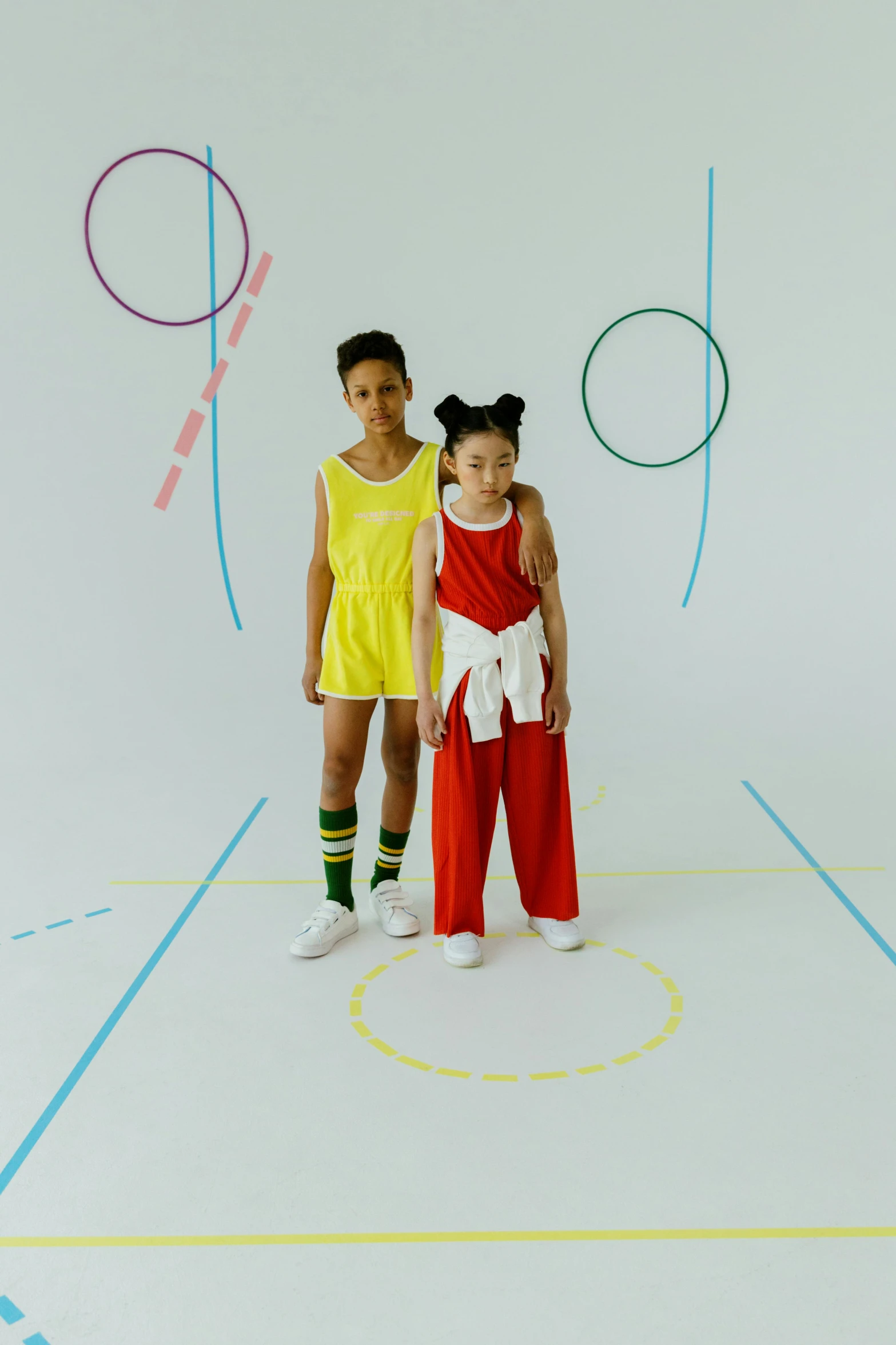 a couple of kids standing next to each other on a basketball court, de stijl, diverse costumes, colors: yellow, off - white collection, joy ang