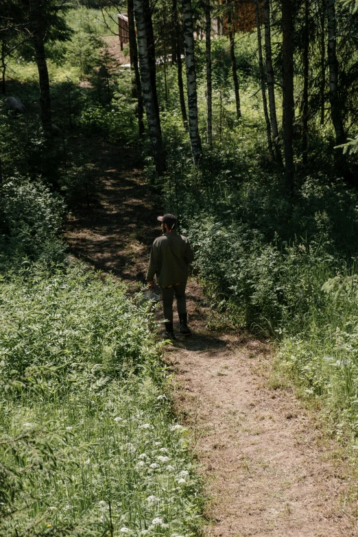 a man walking down a dirt path in the woods, an album cover, by Attila Meszlenyi, unsplash, naturalism, still frame from a movie, ignant, high angle shot, alexey gurylev