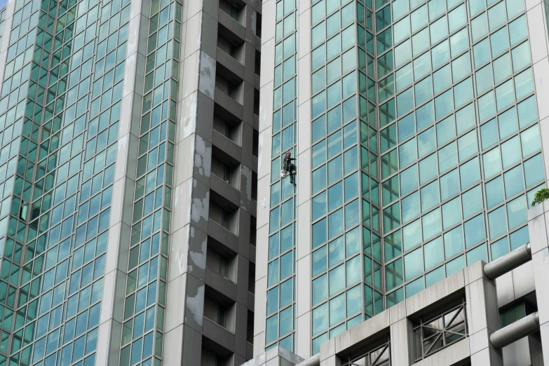 a window washer hanging from the side of a tall building, hurufiyya, te pae, reuters, buildings covered in black tar, “the ultimate gigachad