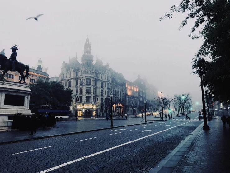 a city street with a statue of a man on a horse, inspired by Elsa Bleda, pexels contest winner, gothic fog, glasgow, background image, fog on the ground