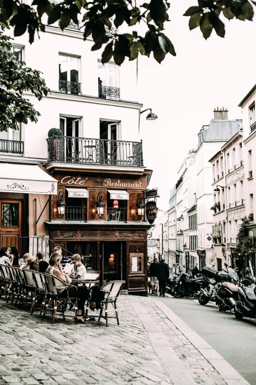 a group of people sitting outside of a building, trending on unsplash, paris school, pub, quaint village, bustling with people, blank