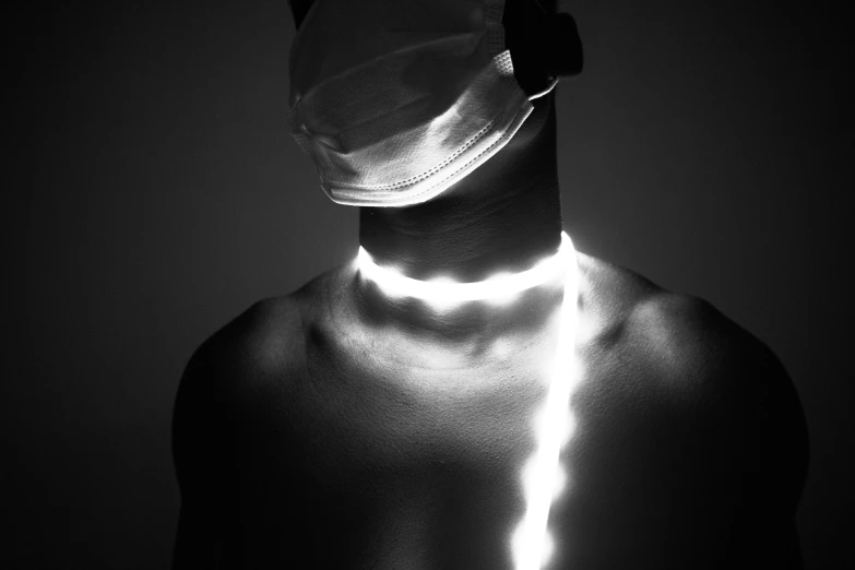 a black and white photo of a man wearing a surgical mask, by Adam Marczyński, afrofuturism, healing glowing lights, cyber necklace, white human spine, white neon