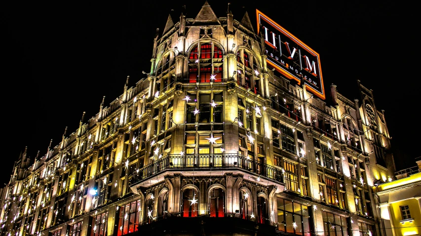 a very tall building lit up at night, art nouveau, river island, humus, profile image, exterior photo