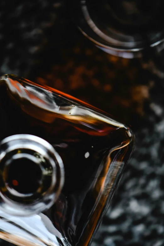 a close up of a bottle of alcohol, a picture, unsplash, visual art, black and brown colors, syrup, thumbnail, medium format