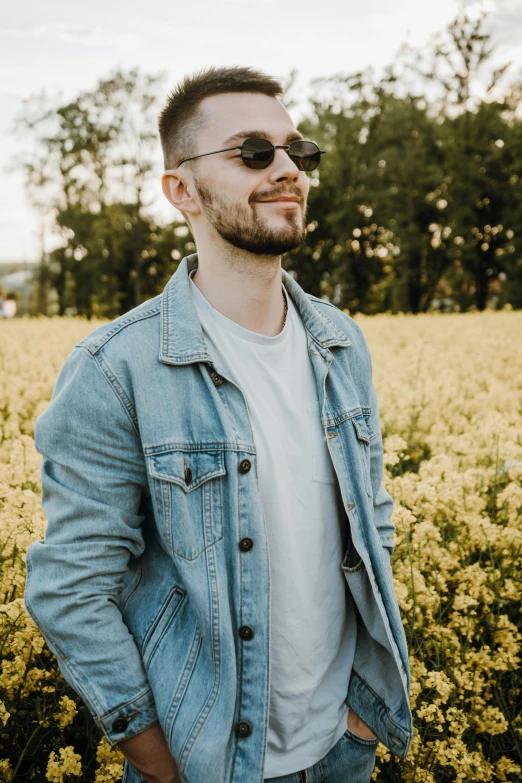 a man standing in a field of yellow flowers, a picture, inspired by Dan Smith, wearing denim, discord profile picture, lean man with light tan skin, slightly smirking