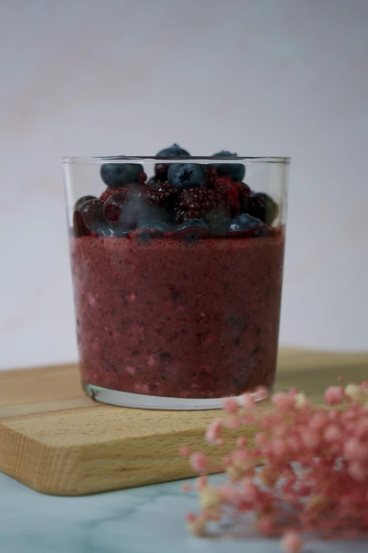 a glass filled with blueberries sitting on top of a cutting board, inspired by Henriette Grindat, reddit, made of flowers and berries, red velvet, rice, 4k)