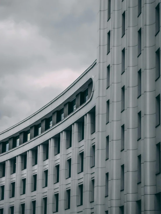 a black and white photo of a building, inspired by Bauhaus, pexels contest winner, in moscow centre, grey cloudy skies, curved, high quality photo