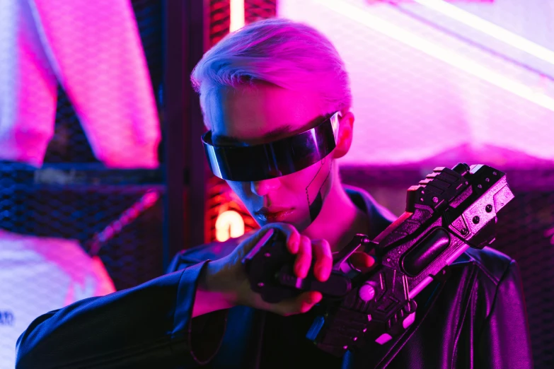 a man in a leather jacket holding a gun, cyberpunk art, pexels, unreal engine : : rave makeup, retro pink synthwave style, futuristic ar glasses, airsoft electric pistol