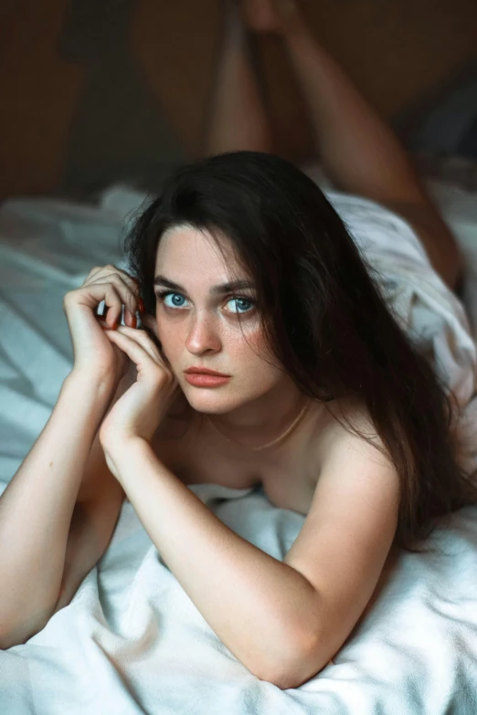 a beautiful young woman laying on top of a bed, inspired by Elsa Bleda, pexels contest winner, renaissance, blue symmetric eyes 24yo, beautiful grumpy girl, metart, gif