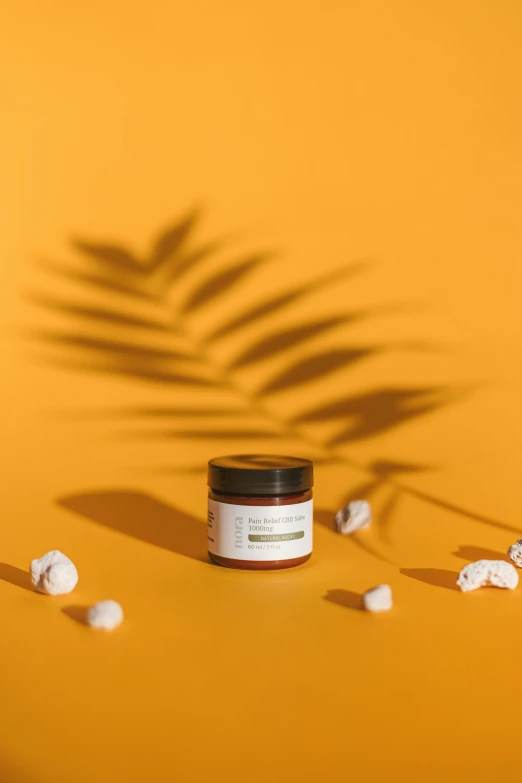 a jar of cream sitting on top of a yellow surface, a picture, by Nina Hamnett, unsplash, lush jungle, product view, soft light from the side, with soft bushes