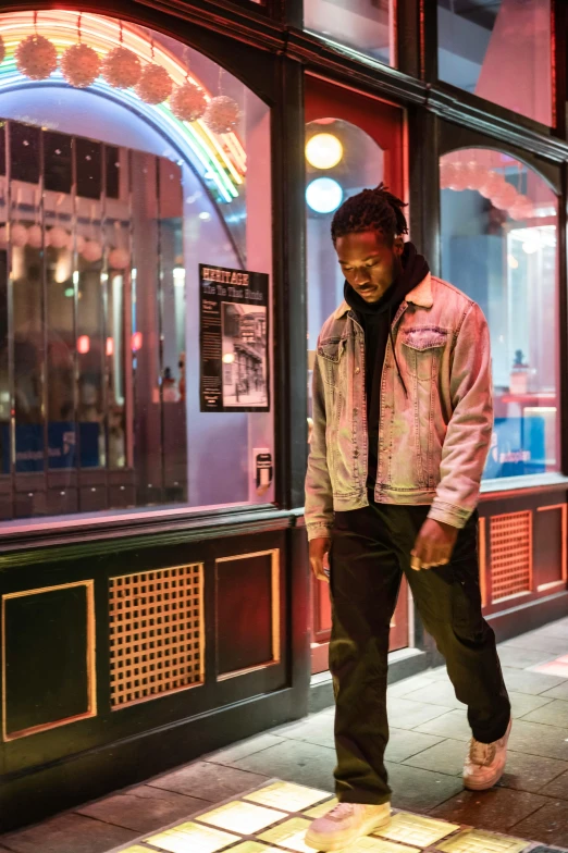 a man standing on a sidewalk in front of a building, an album cover, trending on pexels, cold neon lighting, kendrick lamar, standing in a restaurant, [ theatrical ]