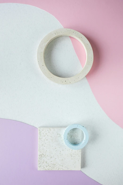 a pair of scissors sitting on top of a piece of paper, an abstract sculpture, inspired by jeonseok lee, trending on unsplash, pastel pink concrete, shaped like torus ring, detailed product photo, dwell