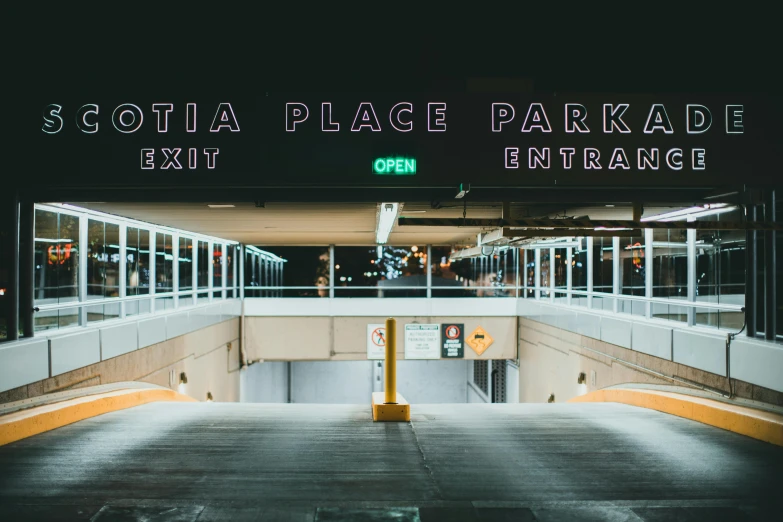 the entrance to a parking garage at night, inspired by Elsa Bleda, pexels contest winner, helvetica, park in background, lolita, scott radke