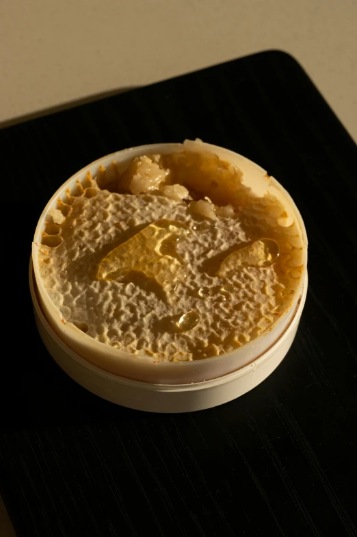 a close up of a bowl of food on a table, a microscopic photo, reddit, hyperrealism, mechanically enhanced honeycomb, blonde cream, celluloid, fungal growth