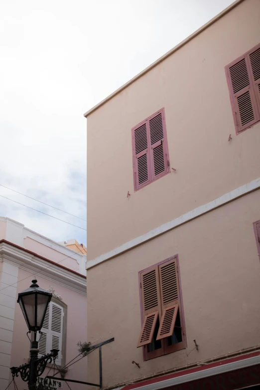 a couple of buildings that are next to each other, inspired by Wes Anderson, arabesque, puerto rico, old town, over-shoulder shot, some pink