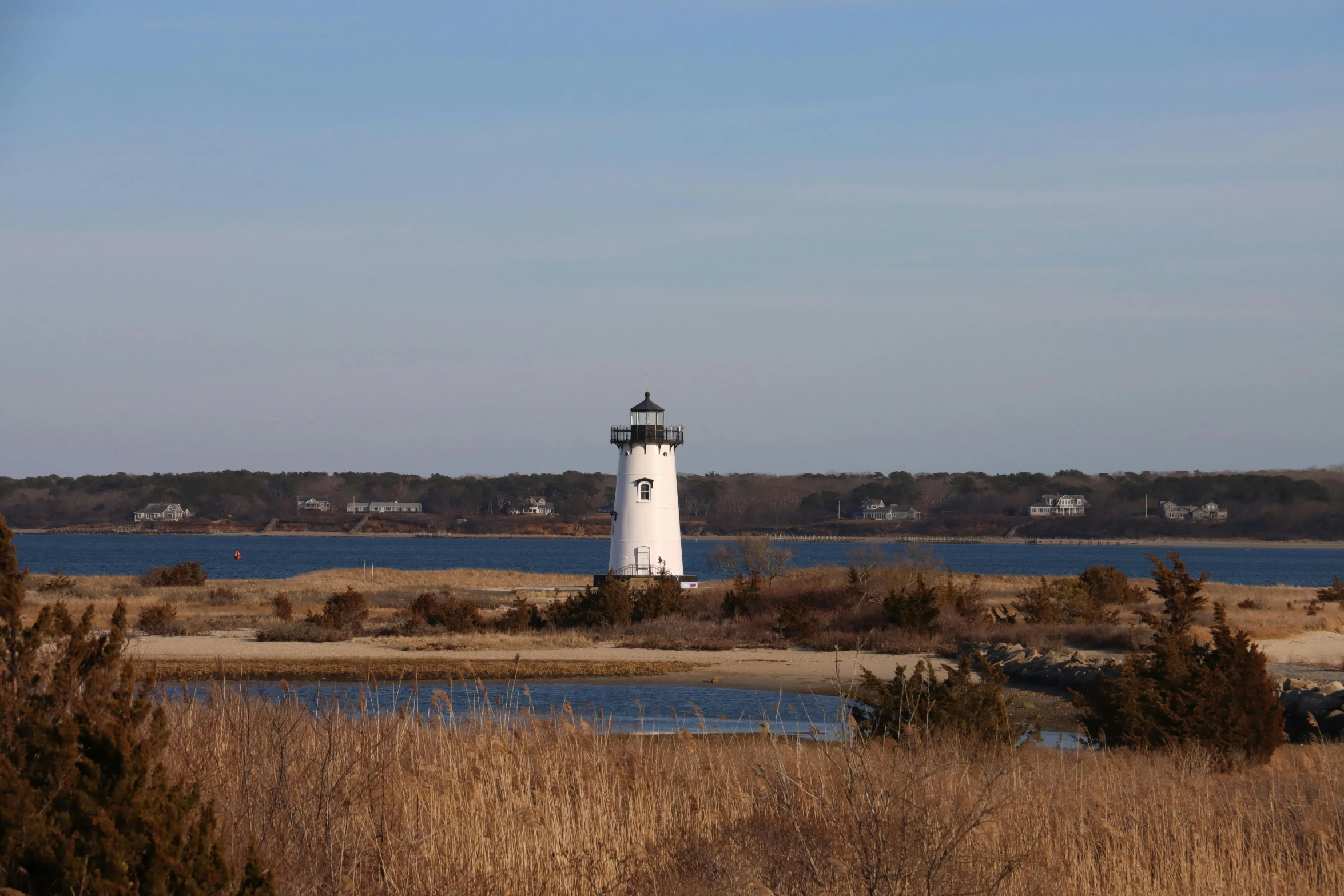 a white light house sitting next to a body of water, a portrait, craigville, gigapixel photo