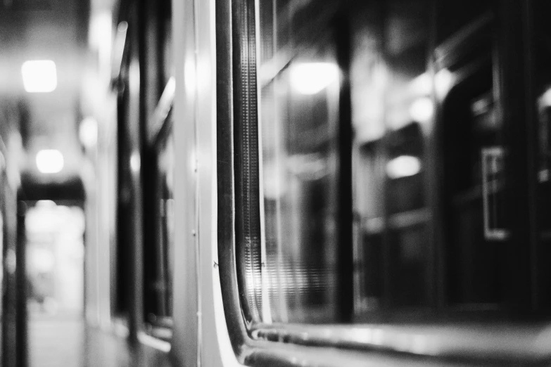 a black and white photo of the inside of a train, unsplash, realism, full of glass. cgsociety, tilt shift glass background, square lines, night mood