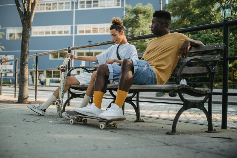 a couple of people that are sitting on a bench, riding a skateboard, gray shorts and black socks, ashteroth, portrait featured on unsplash