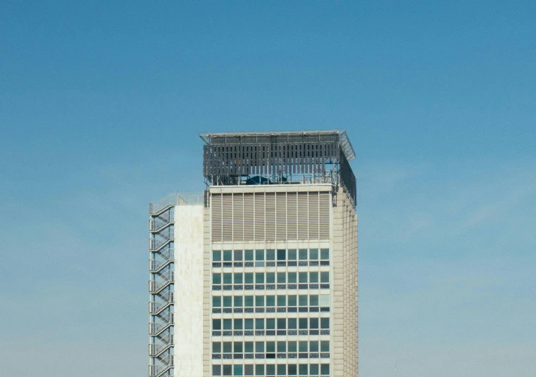 a tall building with a clock on top of it, inspired by Victor Enrich, unsplash, brutalism, blue sky, helipad, maintenance photo, mexico city