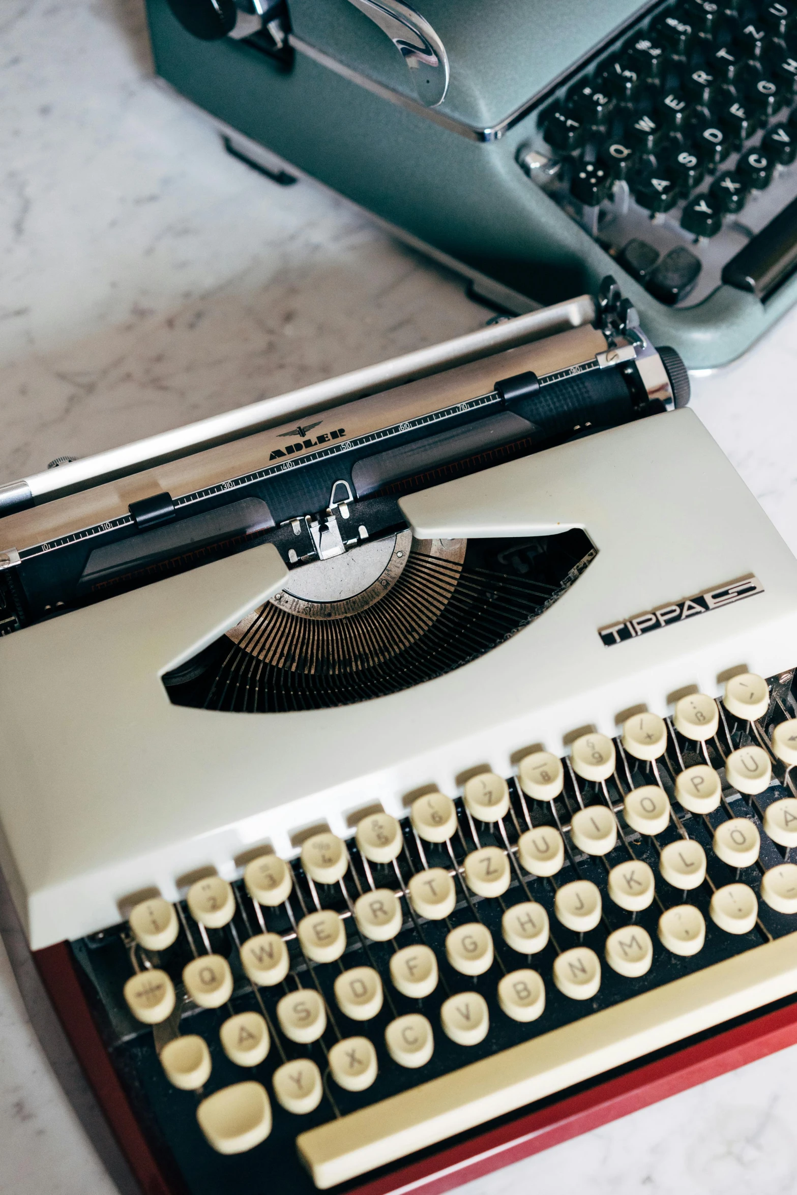 a close up of a typewriter on a table, an album cover, by Nicolette Macnamara, unsplash contest winner, computer aesthetic, white, handheld, retro cover