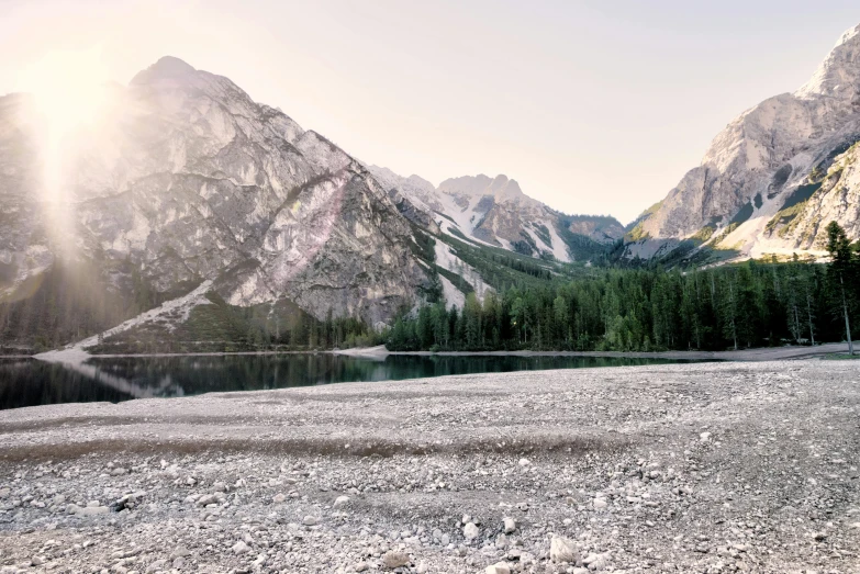 a red fire hydrant sitting on top of a rocky field, by Sebastian Spreng, pexels contest winner, minimalism, mountains river trees, panoramic, gravel and scree ground, sun rises between two mountains