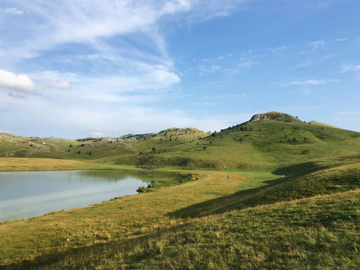 a body of water sitting on top of a lush green hillside, les nabis, in the steppe, magical sparkling lake, csok istvan, comforting and familiar