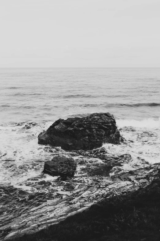 a black and white photo of the ocean, by Bascove, on a rock, ((rocks)), jovana rikalo, oceanside