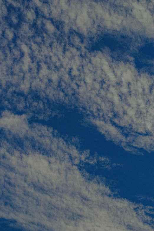 a large jetliner flying through a blue sky, an album cover, unsplash, minimalism, layered stratocumulus clouds, today\'s featured photograph 4k, blue: 0.5, low detail