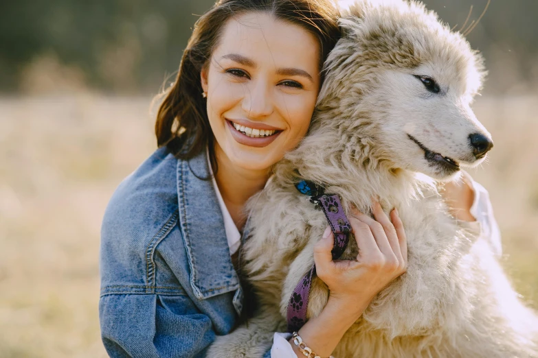 a woman holding a white dog in a field, trending on pexels, furry art, sheep wool, avatar image, australian, genuine smile