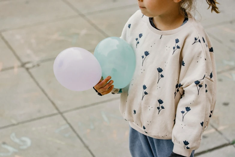 a little girl holding a bunch of balloons, by Emma Andijewska, trending on unsplash, wearing sweatshirt, muted cold colors, 15081959 21121991 01012000 4k, wearing a long flowy fabric