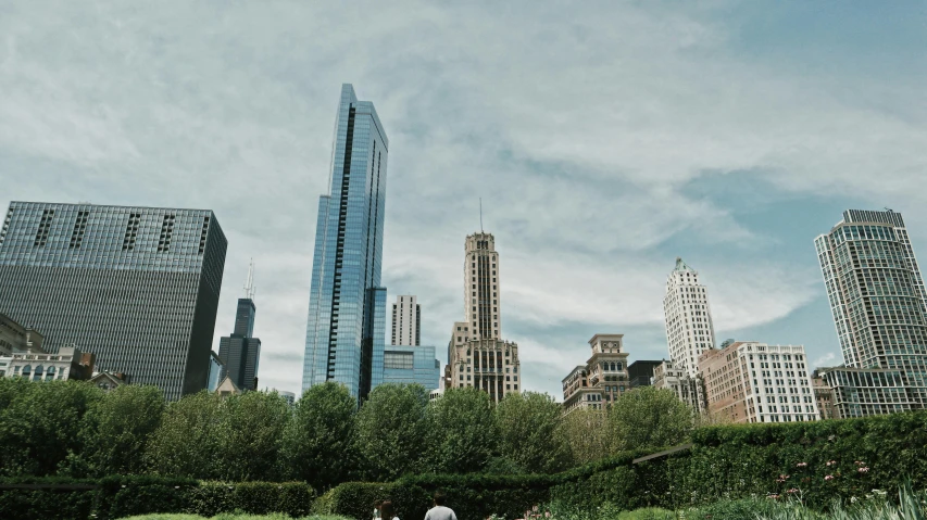 a couple of people standing on top of a lush green field, modern chicago streets, background image