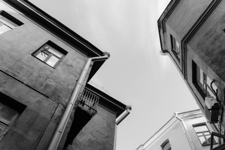 a couple of buildings that are next to each other, a black and white photo, unsplash, anna nikonova, dynamic low angle shot, houses, photographic print