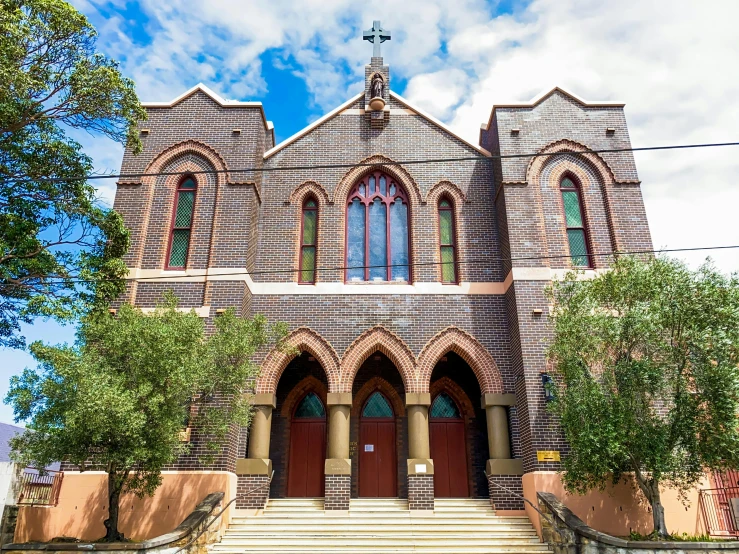 a large brick church with a steeple and a steeple, an album cover, inspired by Sydney Prior Hall, pexels, cloisonnism, view from front, straya, freddy mamani silvestre facade, panoramic shot