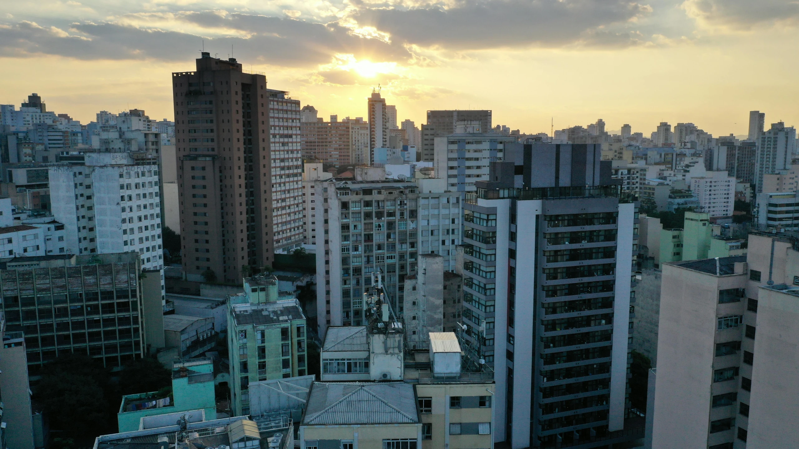 a view of a city from a high rise building, inspired by Antônio Parreiras, pexels contest winner, brutalism, golden hour 8k, gopro photo, outdoors tropical cityscape, poor quality