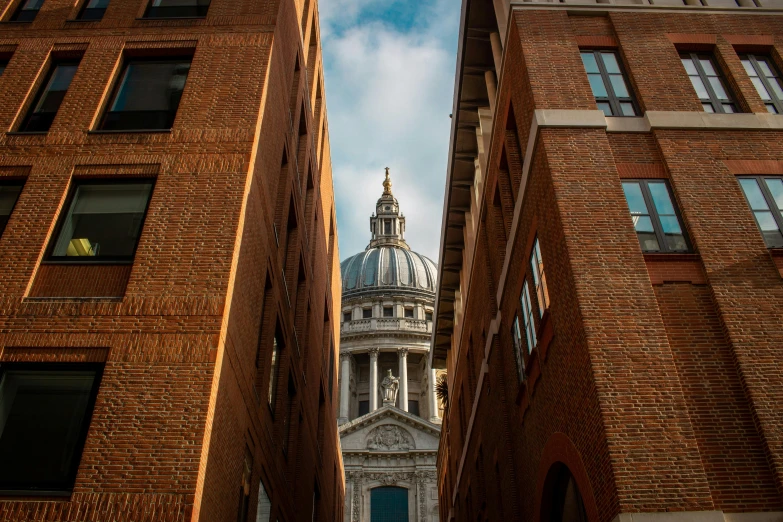 a tall building with a dome on top of it, inspired by Christopher Wren, unsplash contest winner, looking around a corner, brown, shot with sony alpha 1 camera, 2000s photo